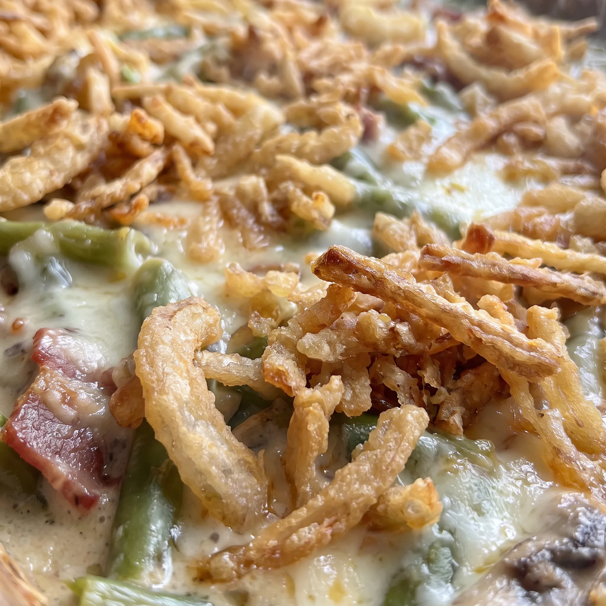 Crisp golden French fried onions over melted Monterey Jack, bacon and mushrooms on green beans.