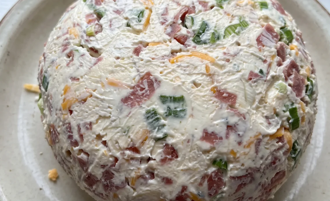 Chipped beef cheese ball coated in green onions and cheddar, surrounded by chipped beef slices.