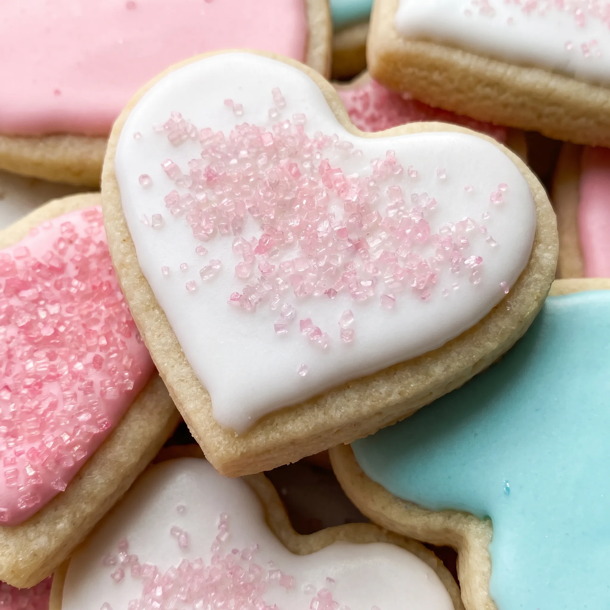 Smooth white royal icing with tiny rainbow sprinkles on a soft cookie.