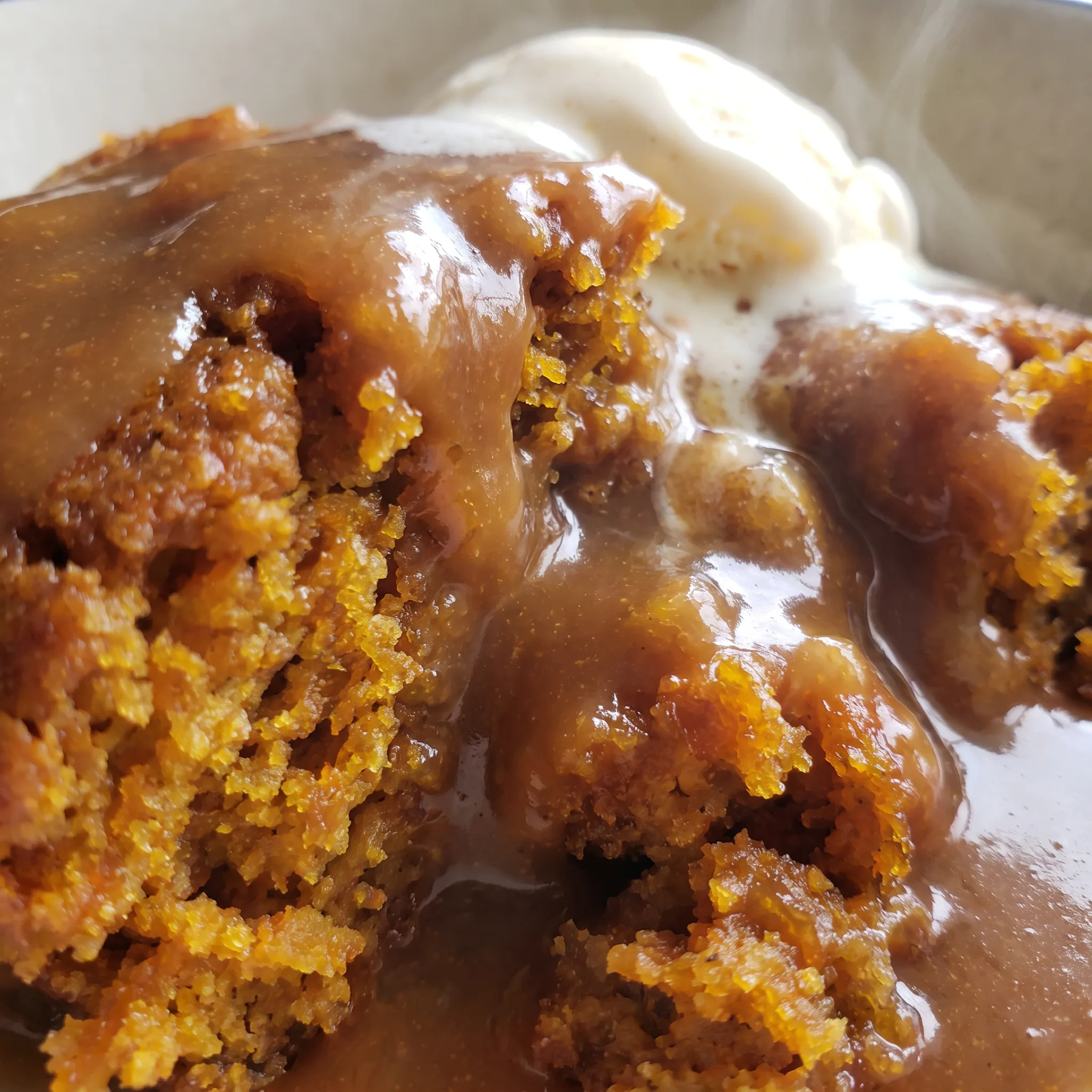 Soft pumpkin filling topped with caramel drizzle, melted chocolate chips, and creamy vanilla ice cream.