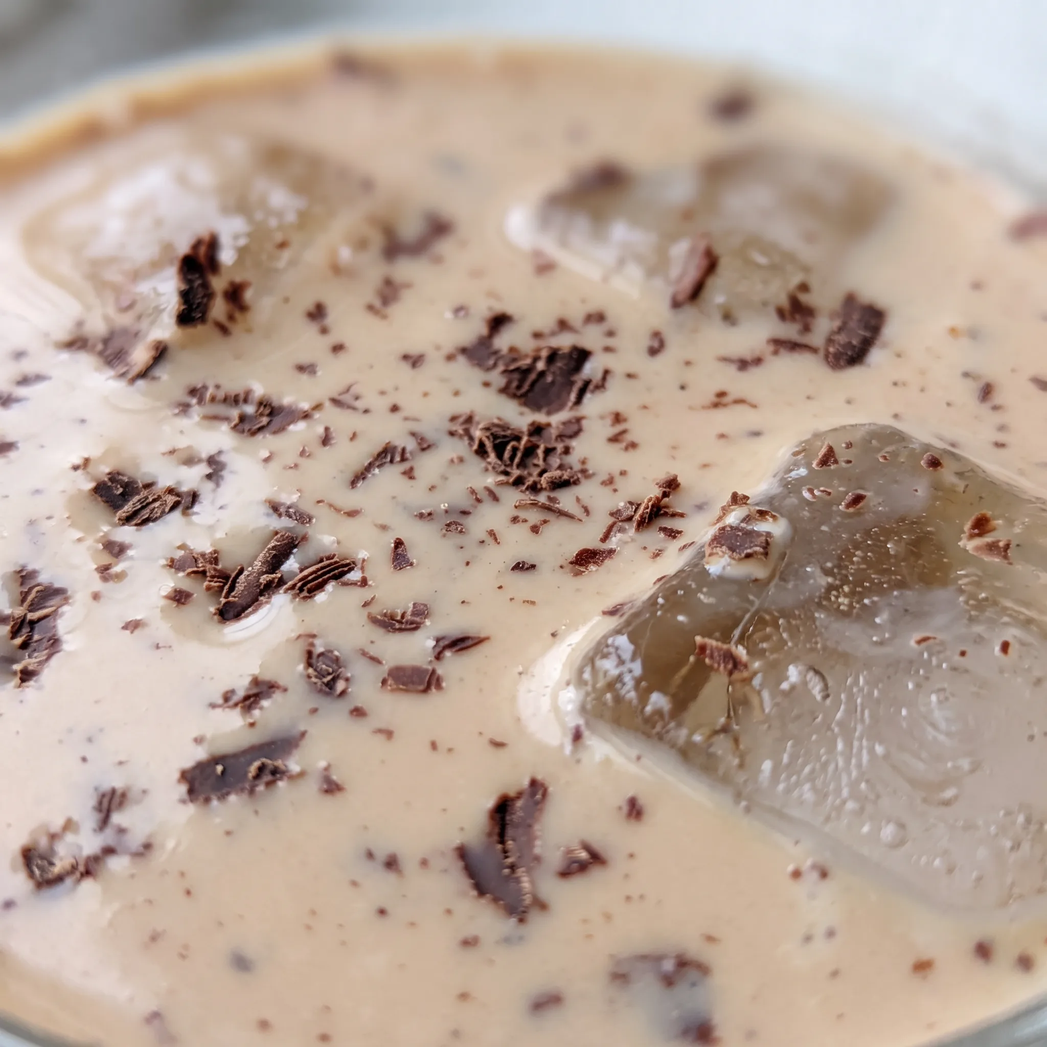 Creamy beige Irish cream with a glossy surface, showing a soft swirl of chocolate syrup.