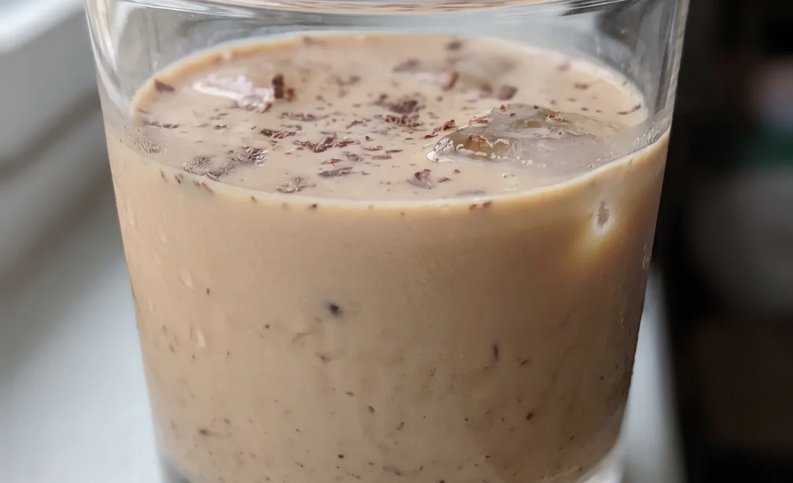 Irish cream liqueur in a glass, pale tan liquid with a smooth creamy surface and a faint chocolate swirl.
