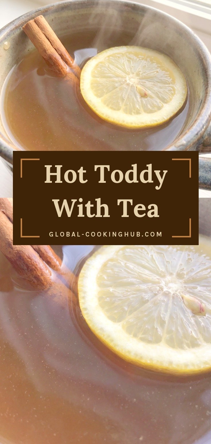 Mug of dark tea toddy with a lemon slice and cinnamon sticks.