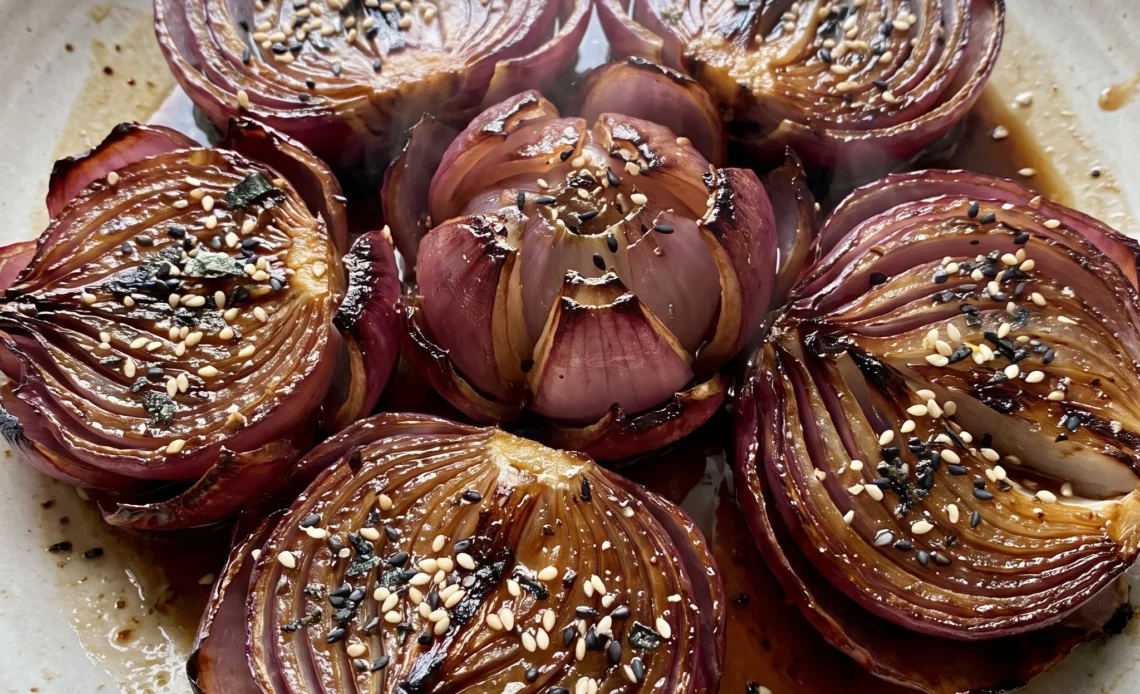 Gluten-free lotus flower onions with red onion petals glazed in honey and rice vinegar, topped with furikake.