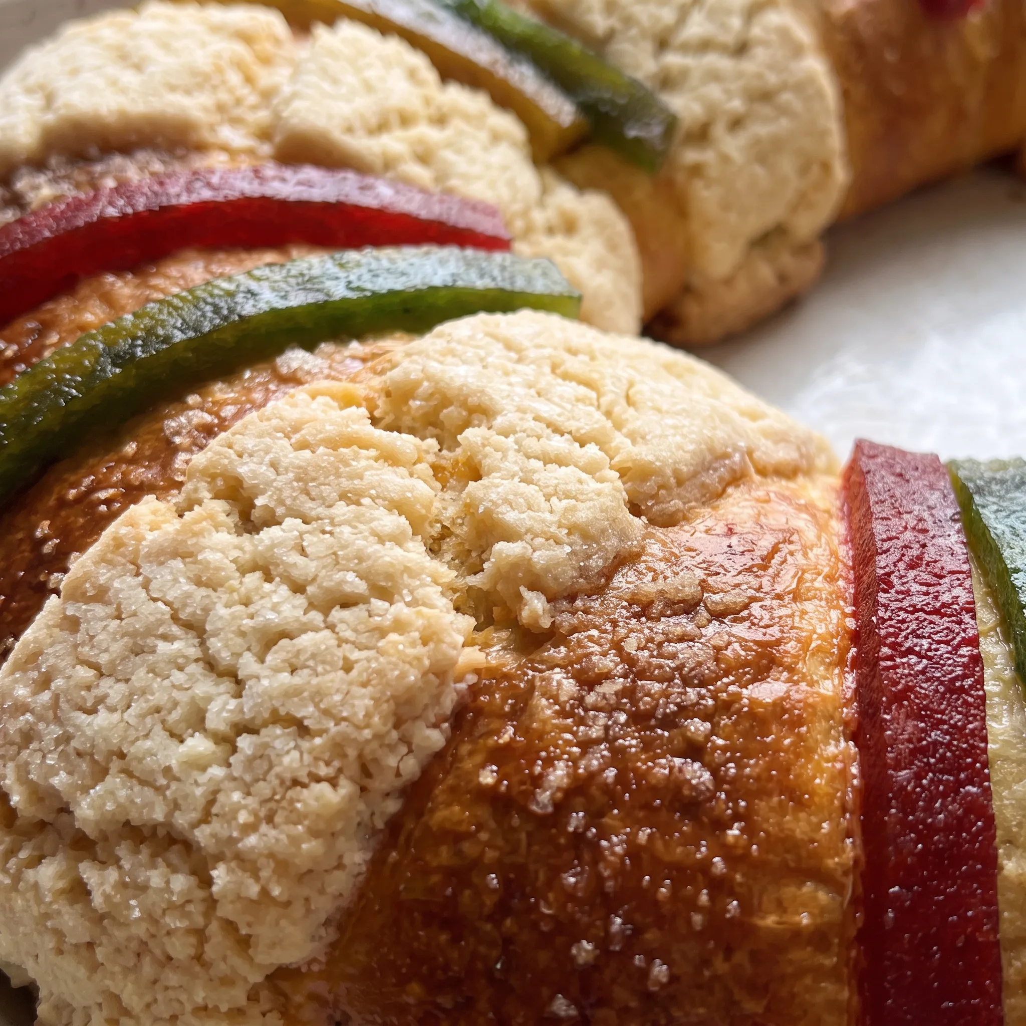 Glossy candied fruit and quince paste pieces with sticky fig chunks and orange zest strips on golden bread.