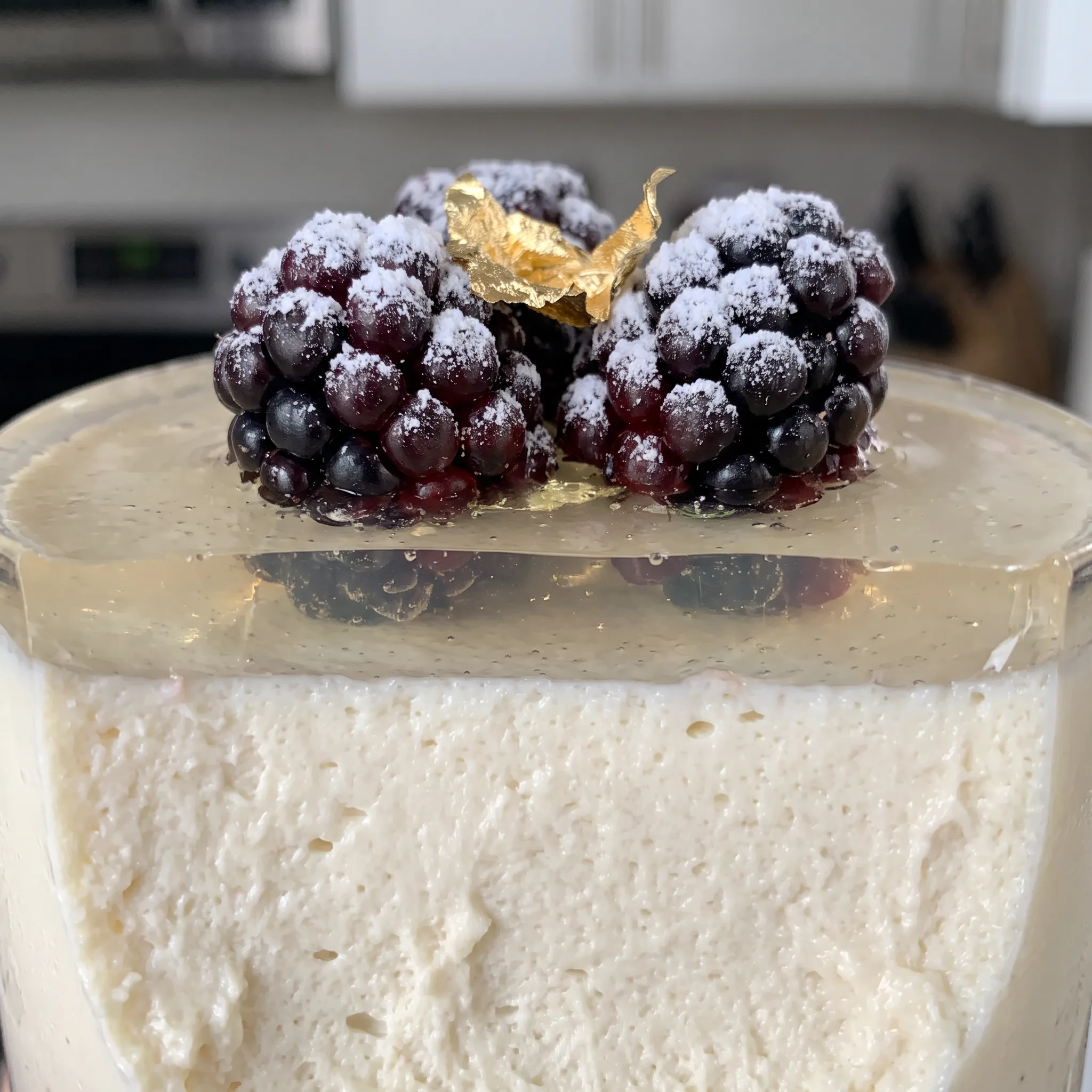 Smooth ivory panna cotta with a soft jiggle, dotted with glistening berries and a light sparkling wine glaze.
