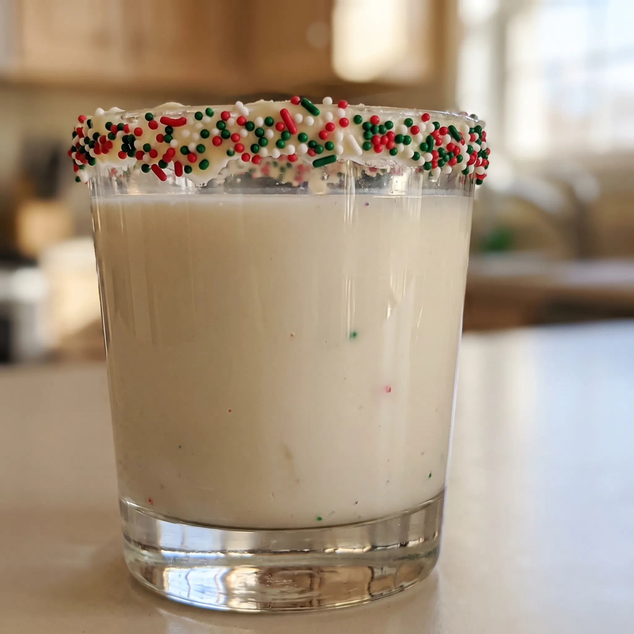 Sugar cookie martini with vanilla frosting rim, sprinkles, and creamy vanilla vodka, Irish cream, and amaretto blend.